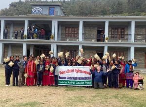 Group of school girls with banner holding kits.